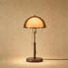 Lampe abat-jour à grande coupole d'ambre allumée, pied de fer à finition noyer | Delvanie