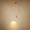 Lampe astronaute Hoshira, globe lune et figurine sur fond minéral beige | Delvanie