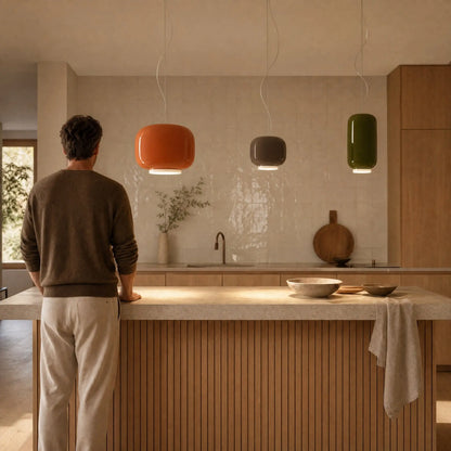 Trio de suspensions en verre coloré ambre, moka et vert olive au-dessus d'un îlot de cuisine | Delvanie