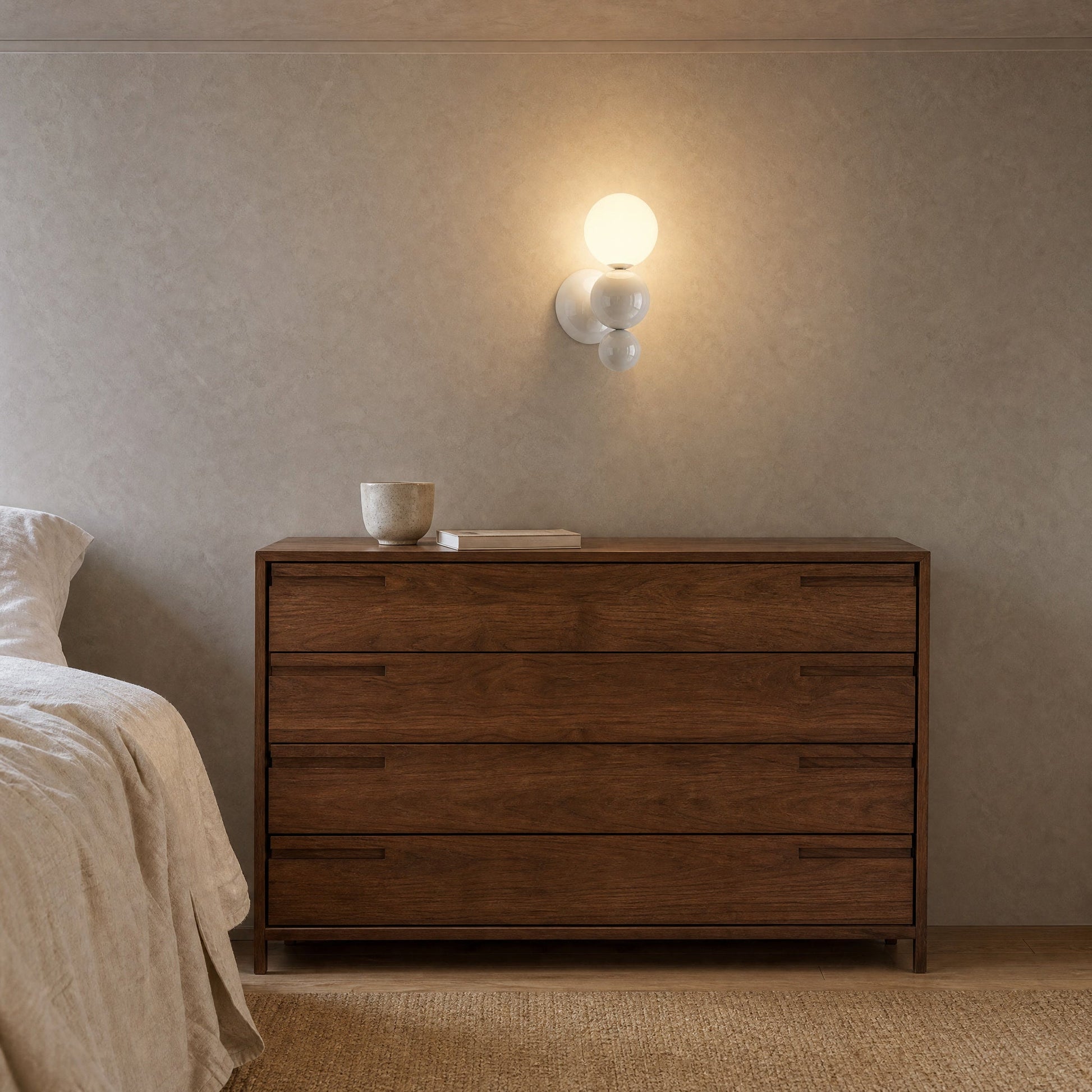 Applique murale boule blanche allumée au-dessus d'une commode en noyer dans une chambre | Delvanie