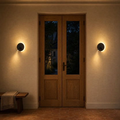 Paire d'appliques murales Falvetta noires allumées de part et d'autre d'une porte à deux vantaux en chêne | Delvanie